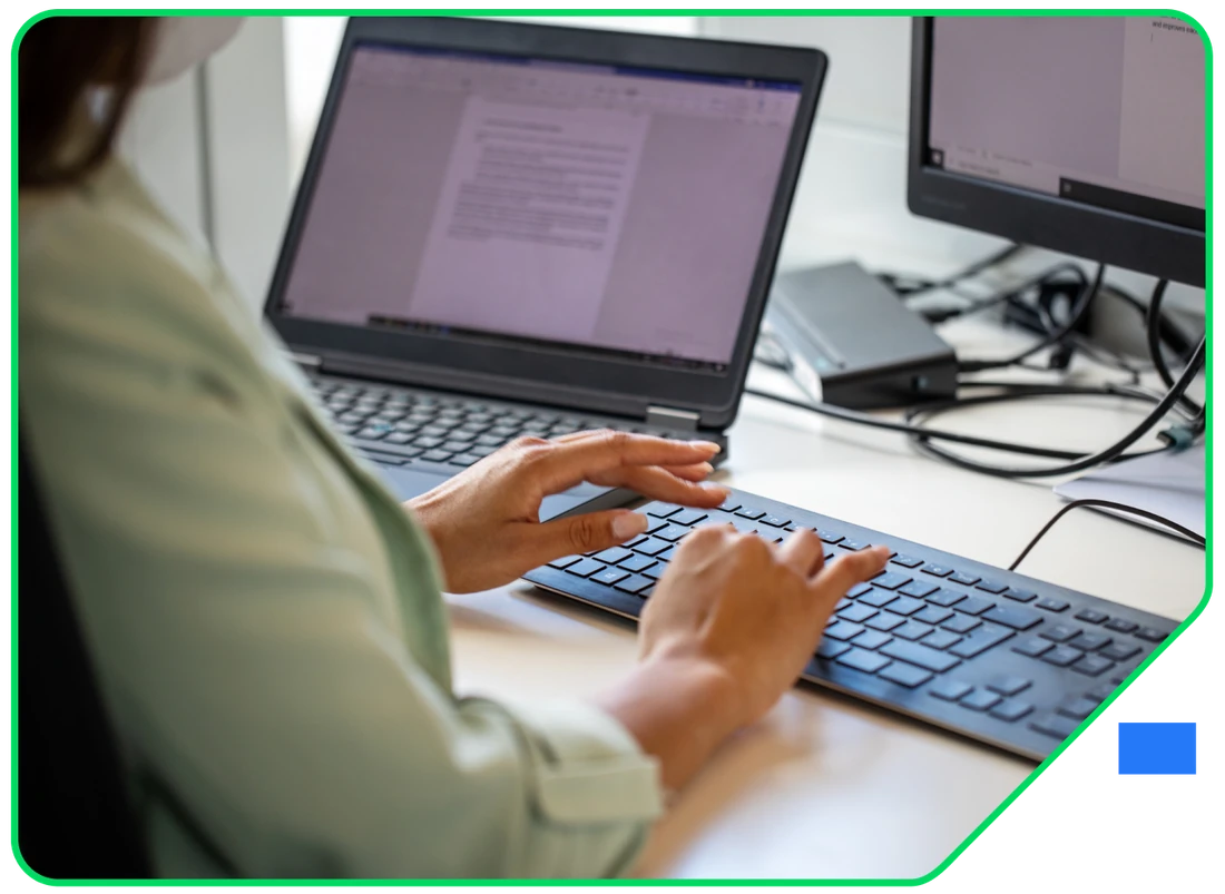 Over-the-shoulder view of someone drafting a document at a keyboard