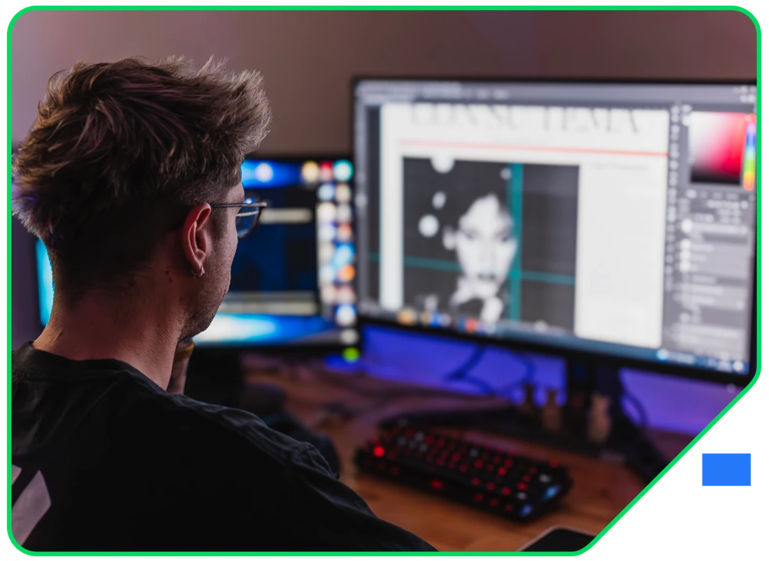 A designer retouching an image across a multi-monitor editing setup